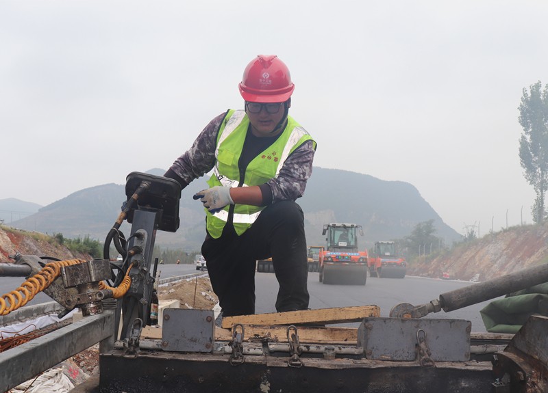 4、油層施工隊長朱紹濤根據(jù)現(xiàn)場實際微調(diào)攤鋪機控制攤鋪質(zhì)量_副本